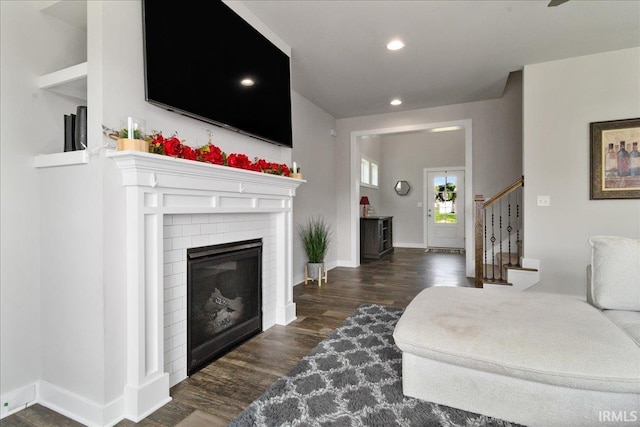 living room with wood finished floors, recessed lighting, stairway, a fireplace, and baseboards