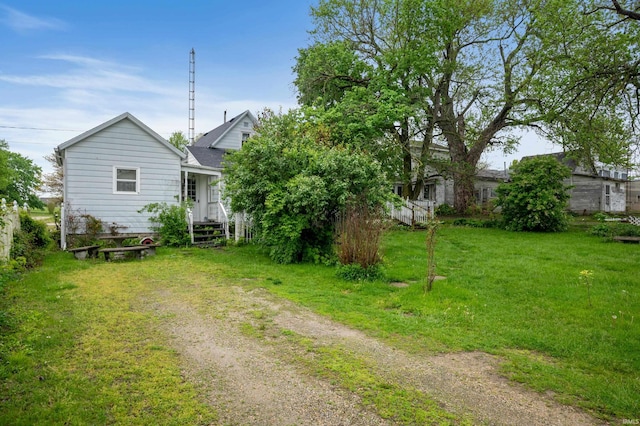 view of green lawn with driveway
