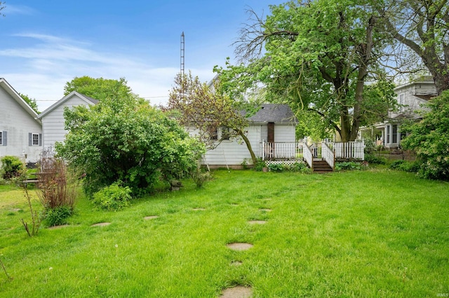 view of grassy yard with a deck