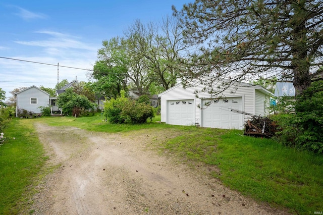 detached garage featuring dirt driveway