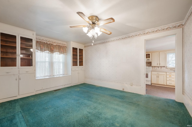 empty room with carpet flooring and a ceiling fan