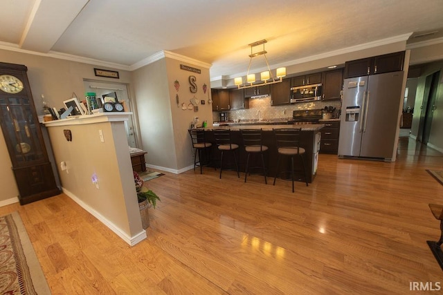 12067 E Bedrock Ln, Springville, IN 47462 - bar area featuring stainless steel appliances, tasteful backsplash, light wood-style flooring, crown molding, and hanging light fixtures