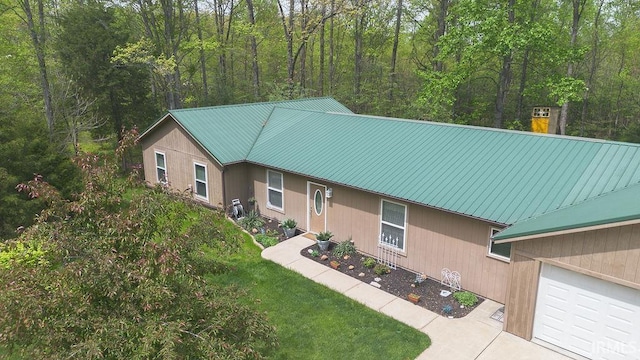 12067 E Bedrock Ln, Springville, IN 47462 - view of home's exterior featuring metal roof, an attached garage, and a yard