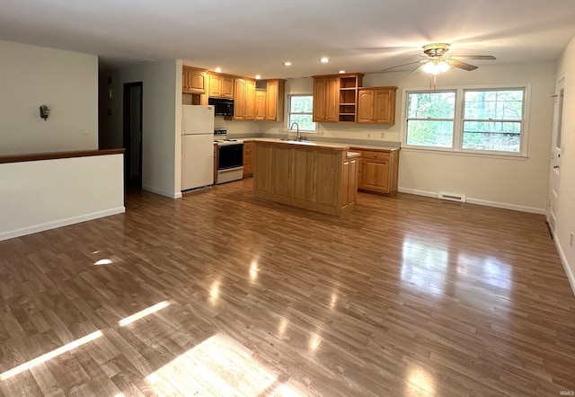 kitchen featuring a sink, white appliances, open shelves, a ceiling fan, and a center island