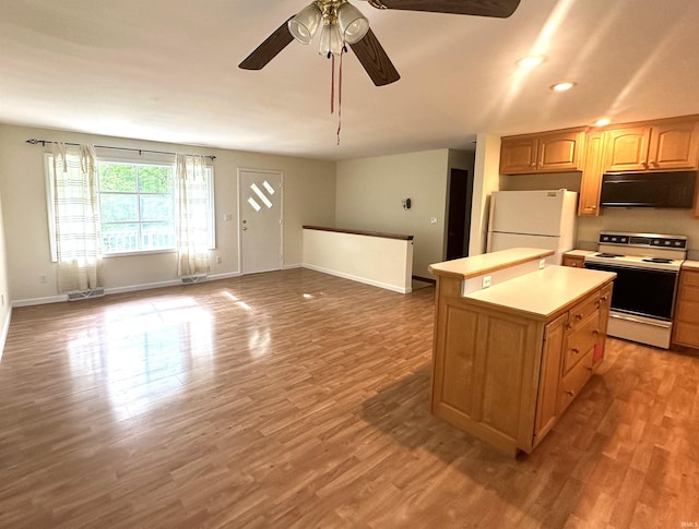 kitchen with electric stove, freestanding refrigerator, a center island, light countertops, and wood finished floors