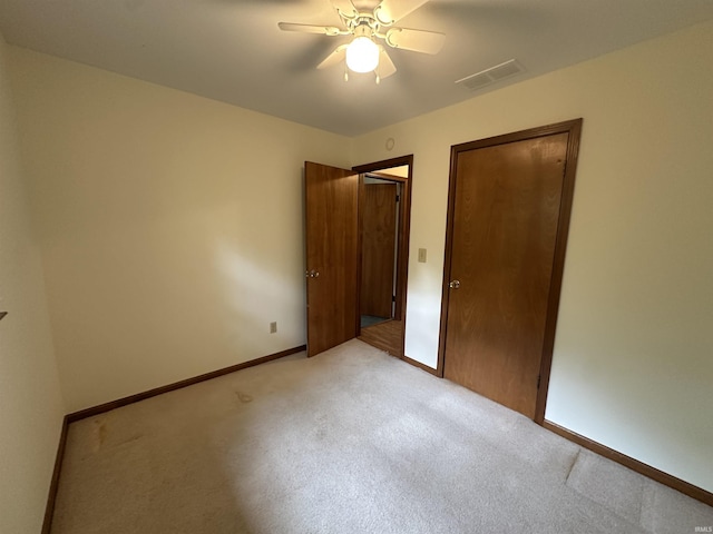 unfurnished bedroom with light colored carpet, baseboards, and ceiling fan