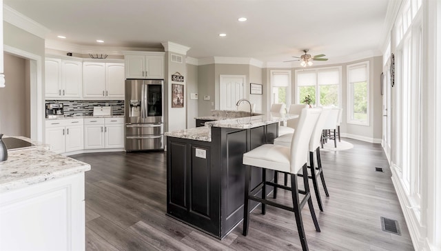 kitchen with stainless steel fridge with ice dispenser, white cabinets, ornamental molding, a ceiling fan, and dark wood finished floors