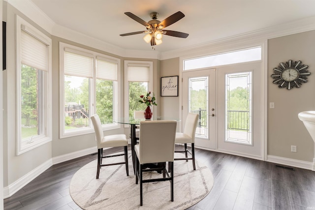 dining space with dark wood finished floors, ceiling fan, baseboards, and crown molding