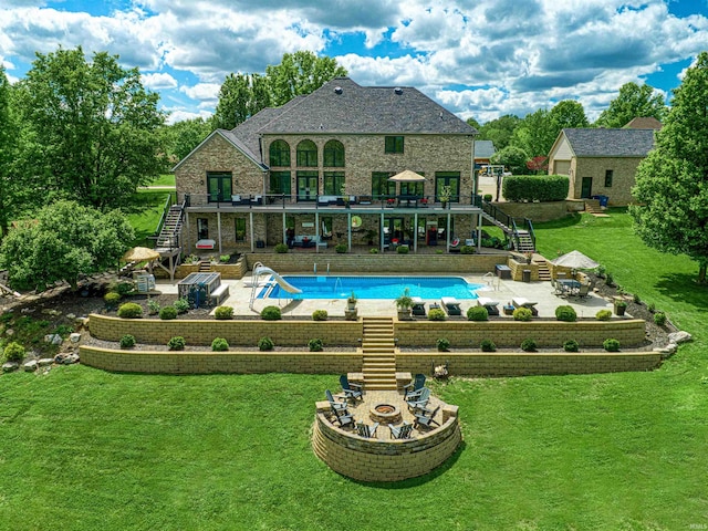 swimming pool with stairs, a water slide, a patio area, and a lawn