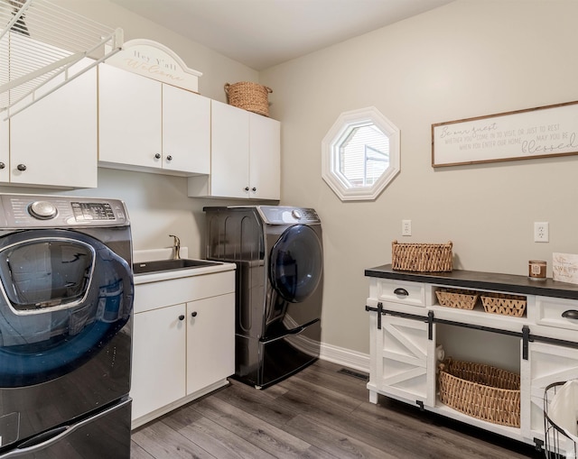 clothes washing area with independent washer and dryer, cabinet space, baseboards, and dark wood-type flooring