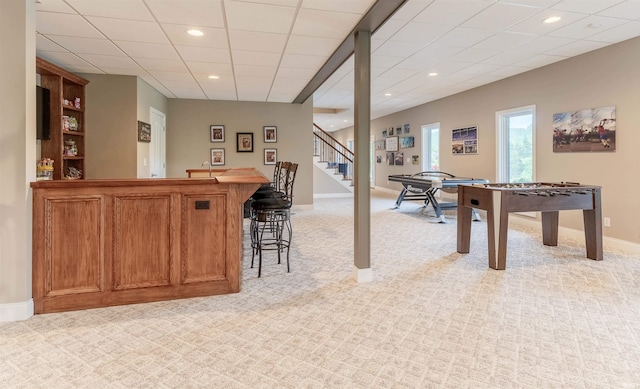 rec room featuring a bar, light carpet, baseboards, and recessed lighting