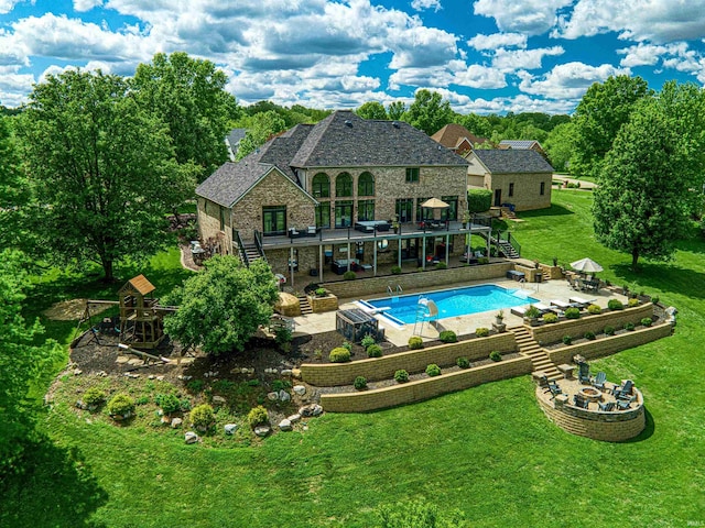 outdoor pool with stairs, a patio area, a yard, a deck, and outdoor dining area
