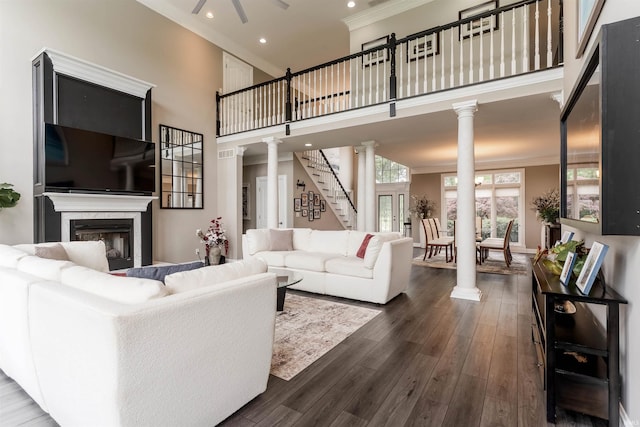 living room with ornate columns, recessed lighting, crown molding, a fireplace, and dark wood-style floors
