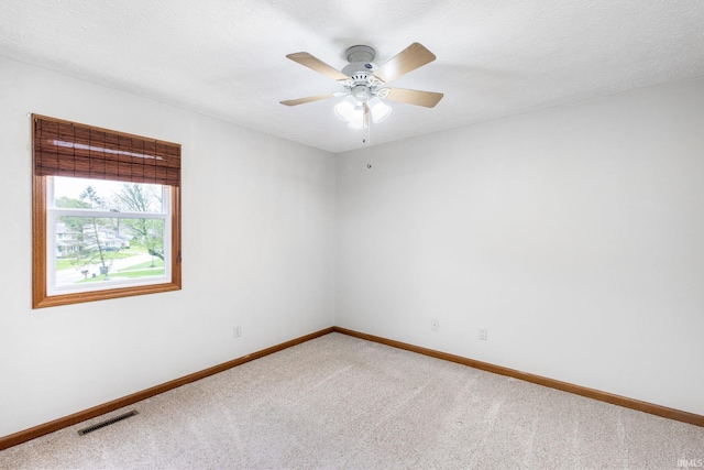 carpeted spare room with baseboards and a ceiling fan