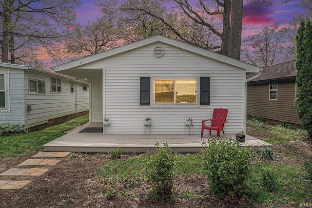 back of property at dusk featuring a deck