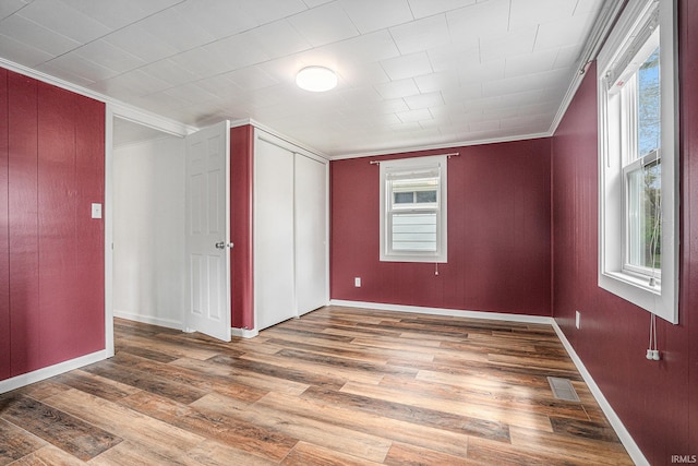 bonus room with wood finished floors, healthy amount of natural light, and baseboards