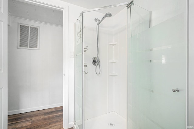 full bath featuring a shower stall, wood finished floors, and baseboards