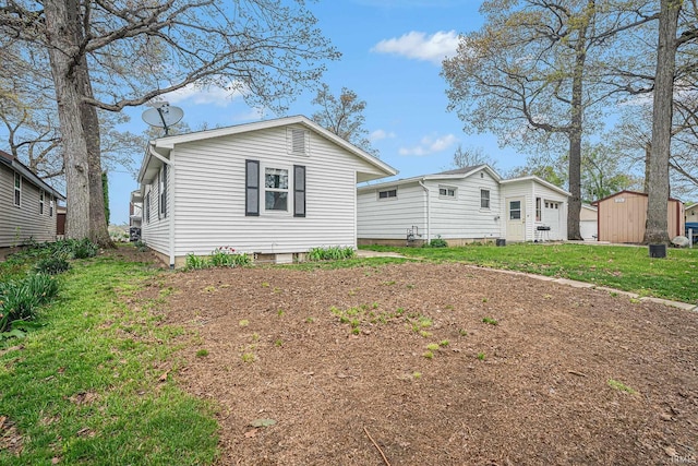 view of front of home featuring an outbuilding, a storage unit, and a front yard