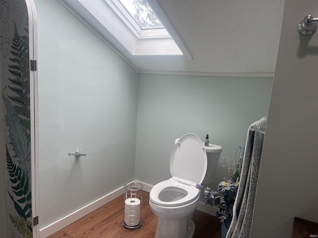 2515 Hubertus Ave, Fort Wayne, IN 46805 - bathroom featuring a skylight, wood finished floors, lofted ceiling, toilet, and baseboards
