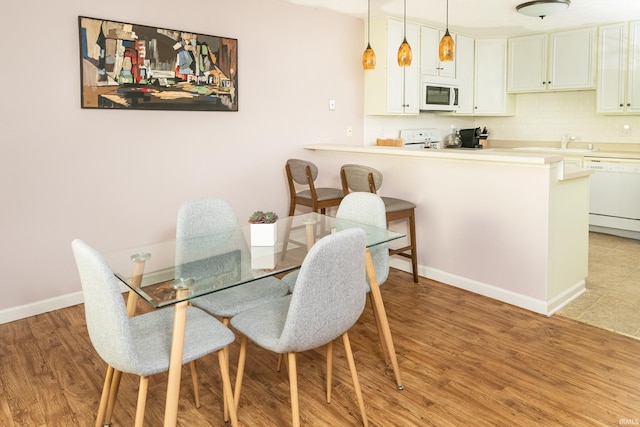 1005 E Buckingham Dr, Bloomington, IN 47401 - dining room with light wood-type flooring and baseboards