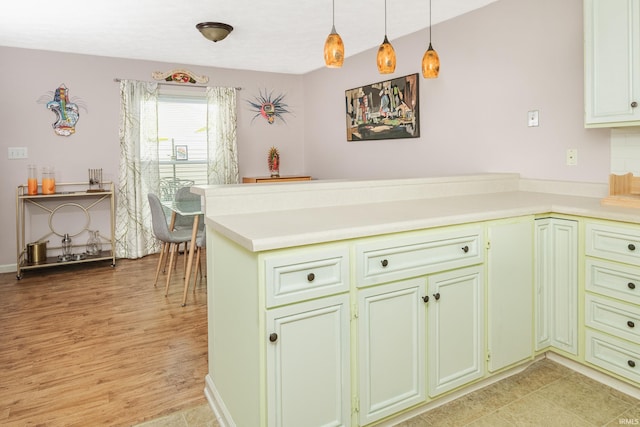 1005 E Buckingham Dr, Bloomington, IN 47401 - kitchen featuring a peninsula, pendant lighting, light countertops, and light wood-style flooring