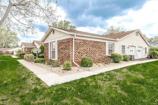 1005 E Buckingham Dr, Bloomington, IN 47401 - view of side of home featuring brick siding, a garage, a yard, and central AC unit
