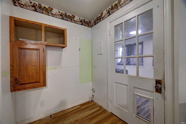 doorway featuring wood finished floors and baseboards