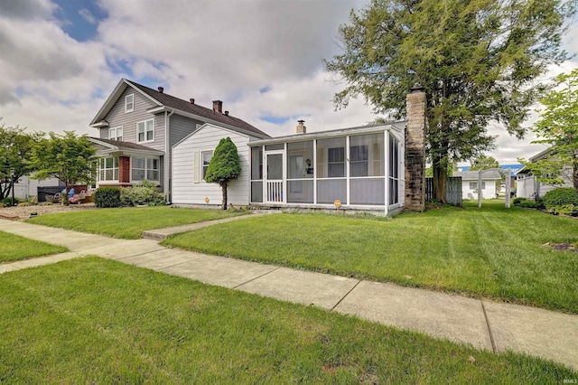 view of front facade with a sunroom and a front yard