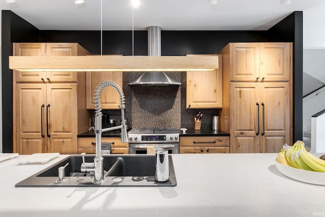 kitchen with a sink, electric range, tasteful backsplash, light brown cabinetry, and wall chimney exhaust hood