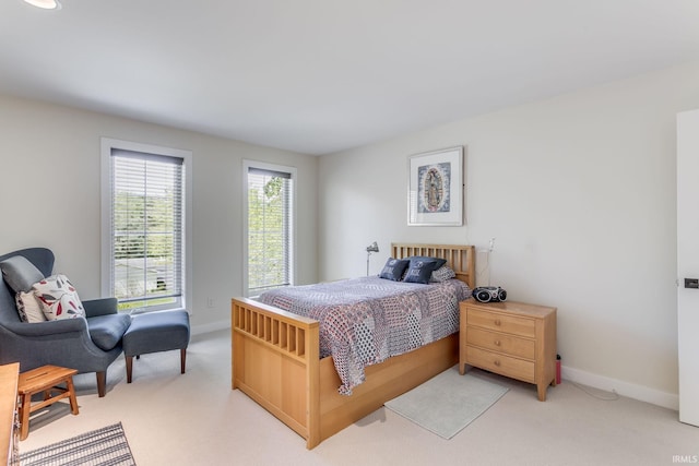 bedroom featuring light carpet and baseboards