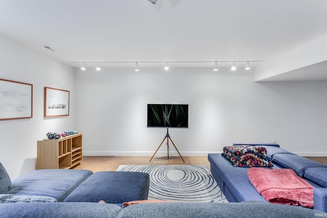 living area featuring track lighting and baseboards
