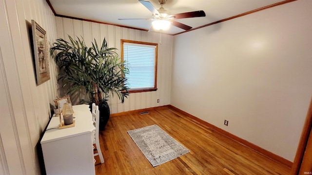 unfurnished room featuring baseboards, ornamental molding, a ceiling fan, and light wood finished floors