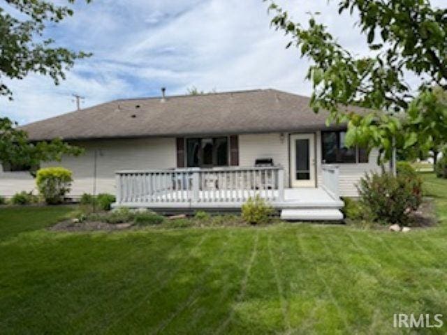 back of house with a wooden deck and a lawn