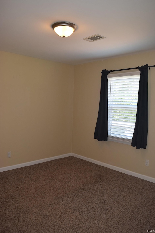 carpeted empty room with baseboards
