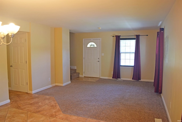 foyer featuring stairway, a chandelier, baseboards, and carpet