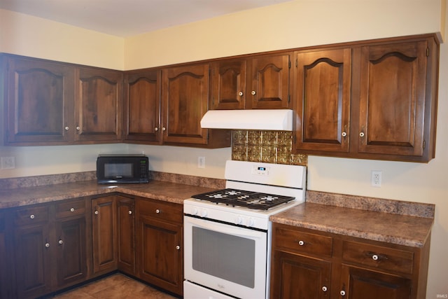 kitchen featuring extractor fan, gas range gas stove, black microwave, and dark countertops