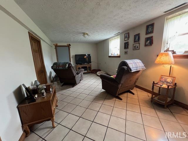 3800 S 175 W, Lafayette, IN 47909 - living room featuring a textured ceiling, light tile patterned flooring, and baseboards