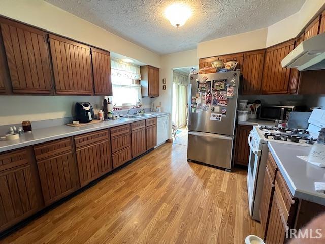 3800 S 175 W, Lafayette, IN 47909 - kitchen with freestanding refrigerator, white range with gas stovetop, under cabinet range hood, black microwave, and a textured ceiling