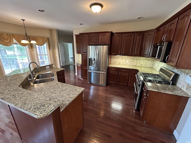 kitchen featuring stainless steel appliances, a sink, dark wood-style floors, backsplash, and recessed lighting