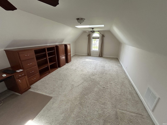 additional living space with a ceiling fan, lofted ceiling, light carpet, baseboards, and a desk