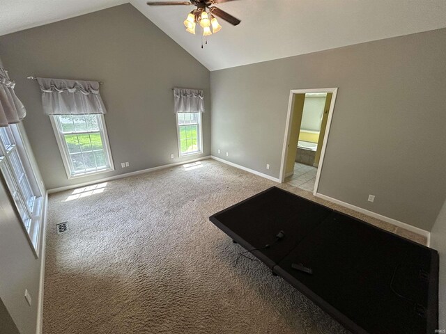 unfurnished room featuring a ceiling fan, high vaulted ceiling, light colored carpet, and baseboards