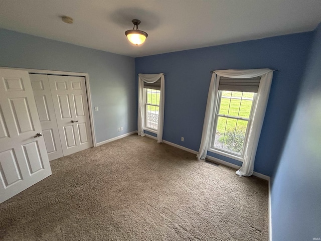 unfurnished bedroom with carpet, baseboards, and a closet