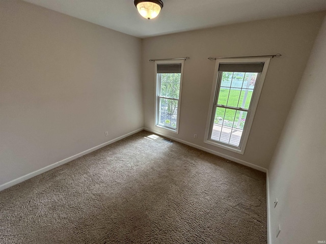 carpeted spare room featuring baseboards