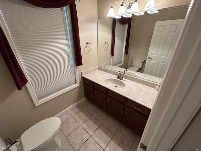 half bathroom featuring toilet, tile patterned flooring, vanity, baseboards, and a chandelier