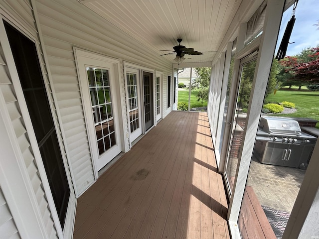 wooden terrace with a ceiling fan and grilling area