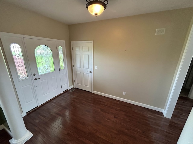 foyer with dark wood-style flooring and baseboards