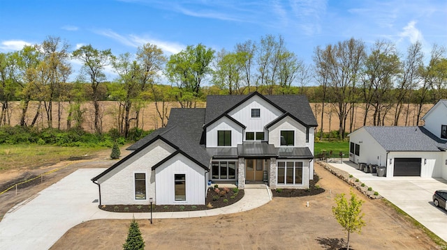 15171 Gossamer Trl, Granger, IN 46530 - modern farmhouse style home with a standing seam roof, concrete driveway, board and batten siding, metal roof, and a shingled roof