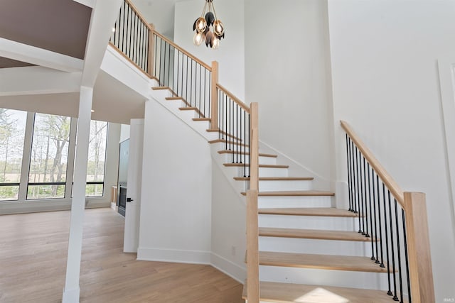 15171 Gossamer Trl, Granger, IN 46530 - stairs with wood finished floors, a chandelier, a towering ceiling, and baseboards