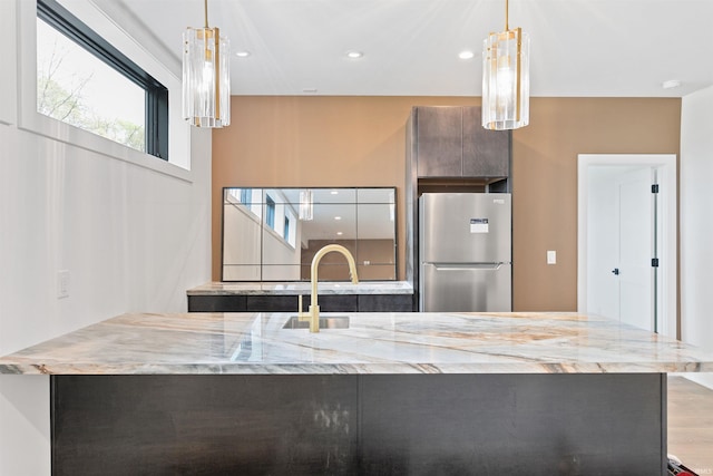 15171 Gossamer Trl, Granger, IN 46530 - kitchen featuring freestanding refrigerator, modern cabinets, a sink, light stone counters, and recessed lighting