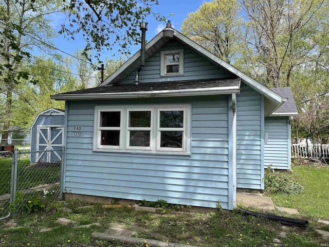 7374 W Upper Bensart Dr, Claypool, IN 46510 - view of side of home with an outdoor structure, a storage unit, and fence